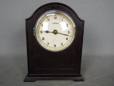 An early 20th century battery electric mantel clock by the Tempex company, arched top bakelite case,