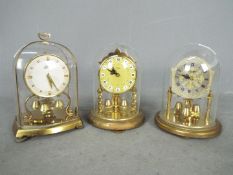 Three miniature anniversary 400-day clocks to include a Schatz 53 model together with two