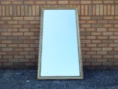 A gilt framed pier mirror measuring approximately 133 cm x 70 cm.