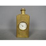 An American advertising mantel clock in the form of a pressed brass bottle embossed with Mother