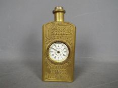 An American advertising mantel clock in the form of a pressed brass bottle embossed with Mother