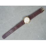 A gentleman's 9ct gold cased wristwatch, the dial signed Avia, on brown leather strap.