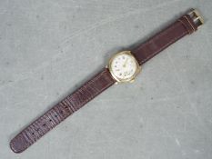 A gentleman's 9ct gold cased wristwatch, the dial signed Avia, on brown leather strap.