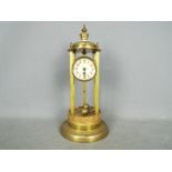 A torsion pendulum mantel clock in a brass and gilded bandstand or tholos style case,