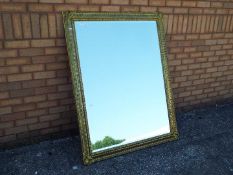 A large gilt framed, bevel edged, mirror
