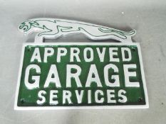 A chrome Jaguar garage services sign,