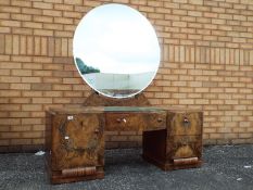 A burr walnut veneered dressing table with circular mirror back,