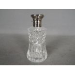 A hallmarked silver and cut glass dressing table scent bottle with enamel decorated top,