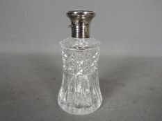 A hallmarked silver and cut glass dressing table scent bottle with enamel decorated top,