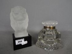 A frosted glass lion head in the Lalique style, mounted to a gloss black glass base,