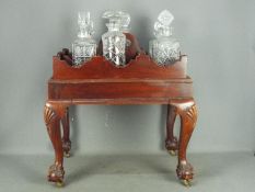 A mahogany stand with carved detailing, on ball and claw,