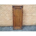 A single door oak wardrobe with carved detailing, approximately 184 cm x 78 cm x 40 cm.