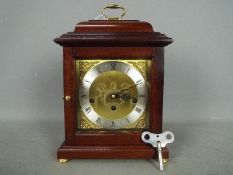 A Comitti of London basket top mantel clock in mahogany case with a Franz Hermle 340-020 movement,