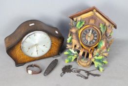 A cuckoo clock and an oak cased mantel clock.