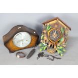 A cuckoo clock and an oak cased mantel clock.