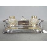 A plated desk tidy with two cut glass inkwells and recumbent greyhound figure to the centre.