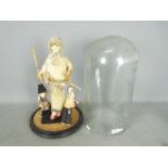 A vintage Oriental doll housed under a glass display dome,
