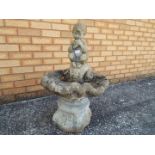 A reconstituted stone bird bath surmounted with pipe playing faun,