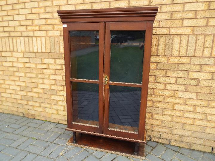 A vintage gun cabinet with twin glazed doors, approximately 147 cm x 93 cm x 28 cm.