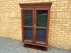 A vintage gun cabinet with twin glazed doors, approximately 147 cm x 93 cm x 28 cm.