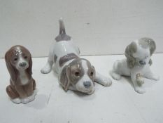 Lladro - Three Ceramic Dog Figures.