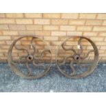 Two cast iron cart wheels or shaft drive wheels, approximately 60 cm (d).