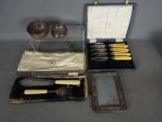 A George V silver fish serving set, Sheffield assay 1925, a silver fronted photograph frame,
