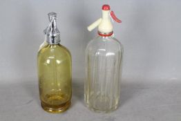 Two vintage soda syphons comprising a yellow Schweppes Limited Porcelain Lined Syphon and a