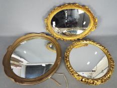 Three decorative wall mirrors, largest approximately 47 cm (d).