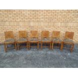 Six dining chairs with upholstered seats and walnut veneered backs.