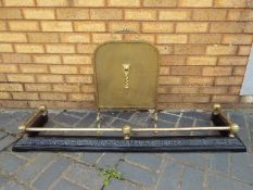 A brass and cast iron fire fender with black painted base,
