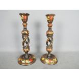A pair of turned and open stem Kashmir candlesticks with typical floral decoration,