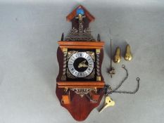 A modern, mahogany and brass Zaanse type wall clock.