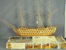 A large, kit built, wooden model of HMS Victory by Mantua Models, housed on a display stand,