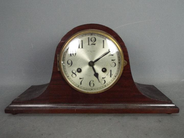 A mahogany cased mantel clock, the silvered dial with Arabic numerals and marked Hy.