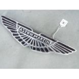 A chrome sign displaying Aston Martin,