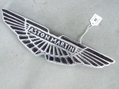 A chrome sign displaying Aston Martin,