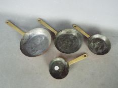 A set of four graduated copper pans
