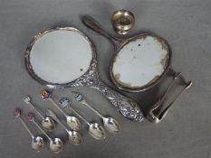 A George V hallmarked silver dressing table hand mirror, a similar white metal example,