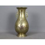 A large Oriental, twin handled brass baluster vase,