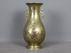 A large Oriental, twin handled brass baluster vase,