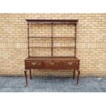 A George III style kitchen dresser with three drawers to the base,