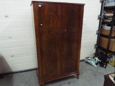 A good quality twin door wardrobe with fitted interior, raised on four supports,