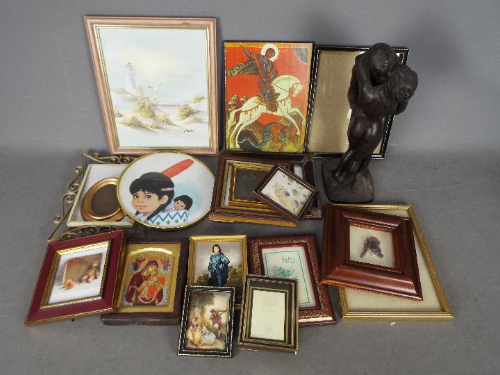 A collection of pictures, picture frames, religious icons and similar.