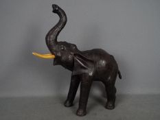 A vintage leather elephant with raised trunk, approximately 50 cm (h) to tip of trunk.