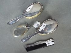 Three George V silver backed, dressing table pieces comprising two brushes and a comb,