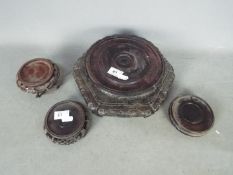 Four Oriental wooden stands, the largest approximately 9 cm x 26 cm.