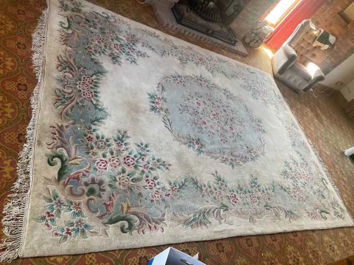 A large rug with floral decoration on a cream ground, approximately 370 cm x 110 cm.