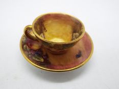 James Skerrett (British, b 1954) - a miniature cup and saucer hand painted with fruits,