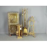 A brass fireside companion set, a smaller set and a brass bound umbrella or stick stand.
